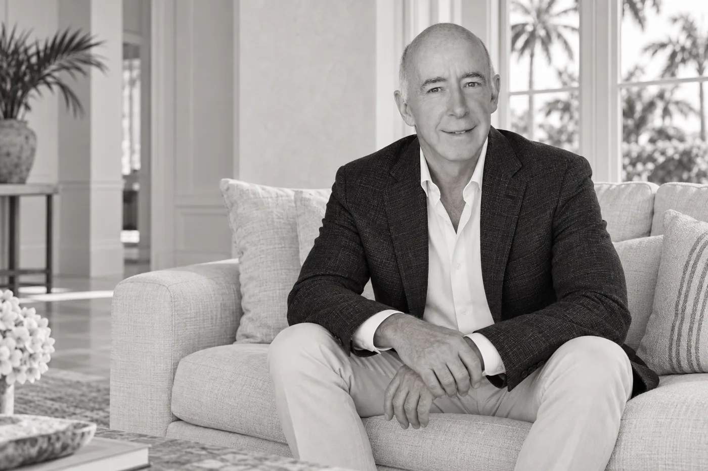 Black-and-white concept portrait of David Abernathy seated on a sofa in a Palm Beach inspired interior