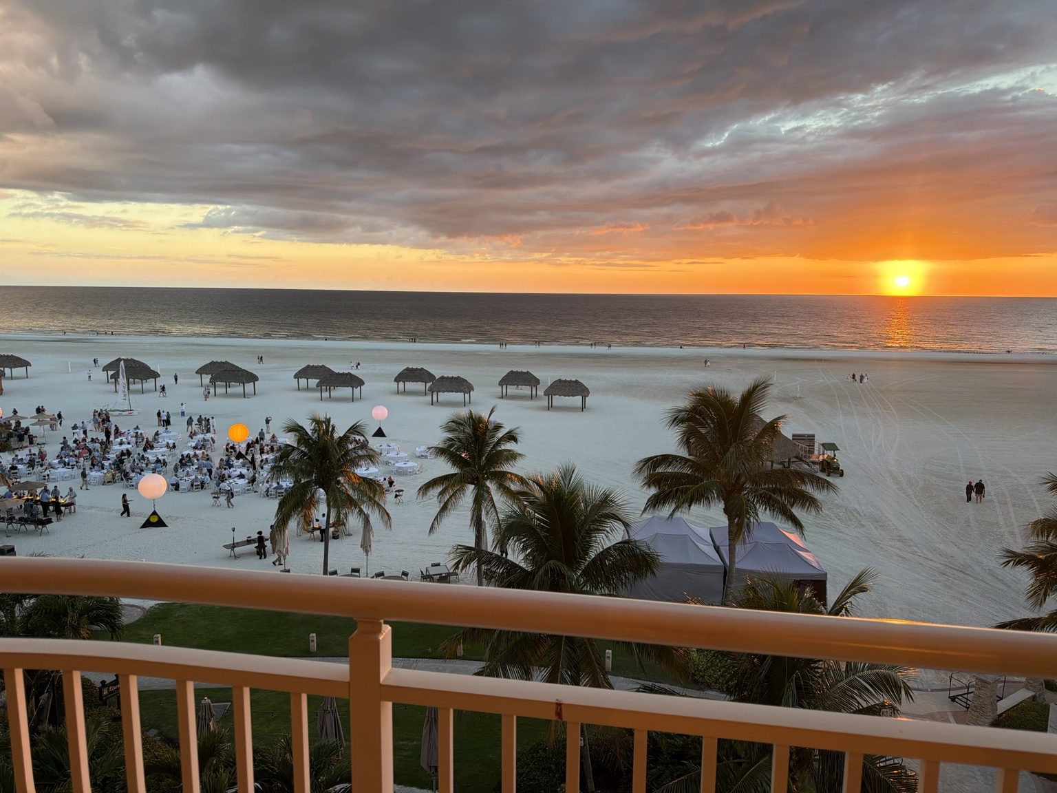 Sunset over the Gulf of Mexico, a beach gathering and palm trees viewed from David Abernathy’s room in Marco Island.